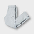 White Nike trackpants featuring dark side piping and embroidered Swoosh logo