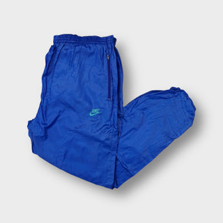 Nike trackpants in blue featuring an embroidered teal swoosh logo below the pocket