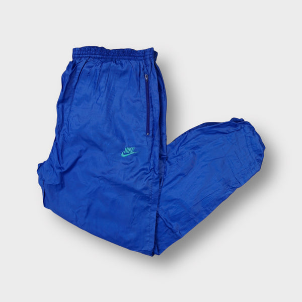 Nike trackpants in blue featuring an embroidered teal swoosh logo below the pocket