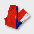 Reebok trackpants in red with blue side stripes and white lower leg zips
