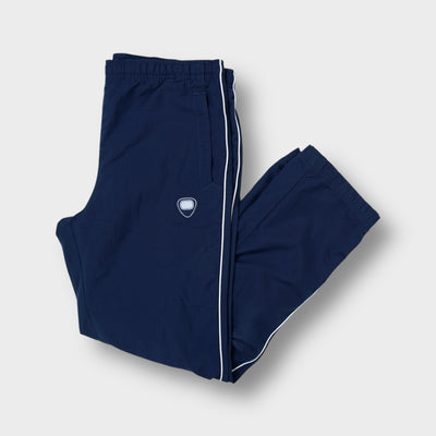 Nike trackpants in navy blue featuring white side piping and an embroidered hip crest
