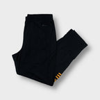 Black Adidas trackpants with gold lower-leg stripes and embroidered logos