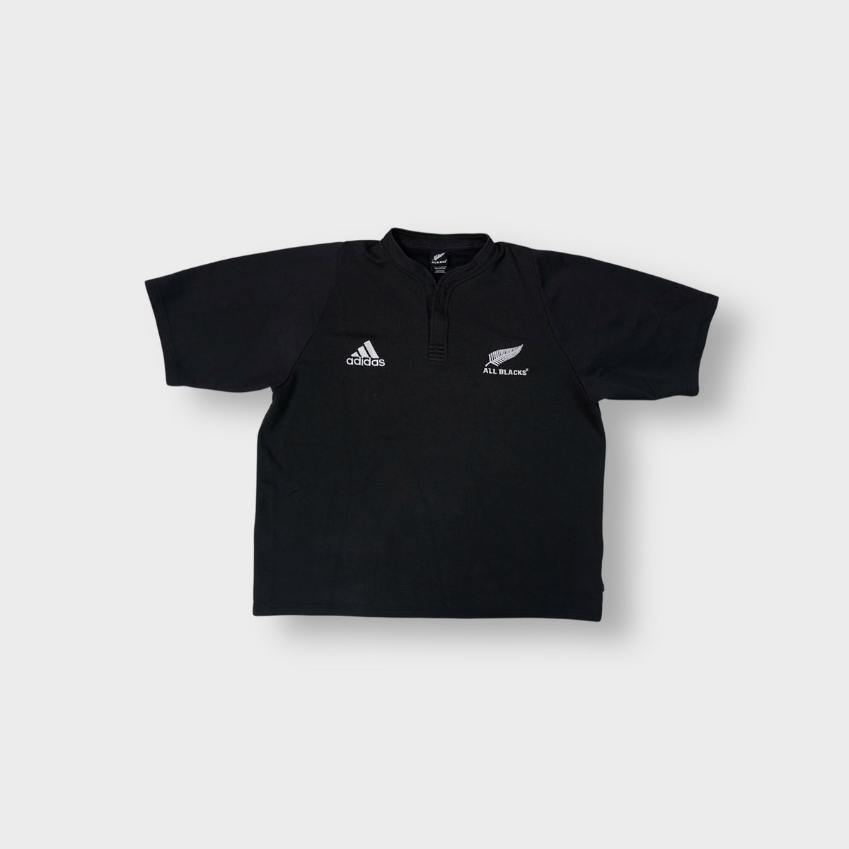Black Adidas shirt with white embroidered Adidas and All Blacks fern logos on the chest.