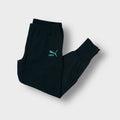 Black Puma trackpants with an embroidered turquoise logo on the upper thigh