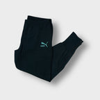 Black Puma trackpants with an embroidered turquoise logo on the upper thigh