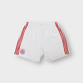 White Adidas FC Bayern shorts featuring red side stripes and an embroidered team crest.