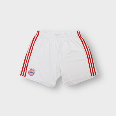 White Adidas FC Bayern shorts featuring red side stripes and an embroidered team crest.