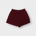 Nike shorts in red with front pleats, button waistband and tonal embroidered logo