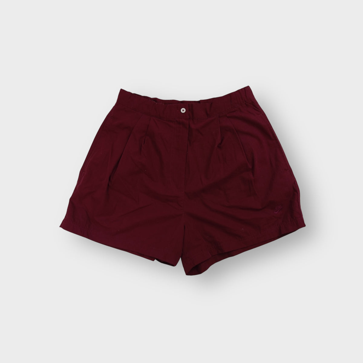 Nike shorts in red with front pleats, button waistband and tonal embroidered logo