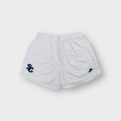 Nike white 90s shorts featuring an embroidered dark green SC emblem on the hem