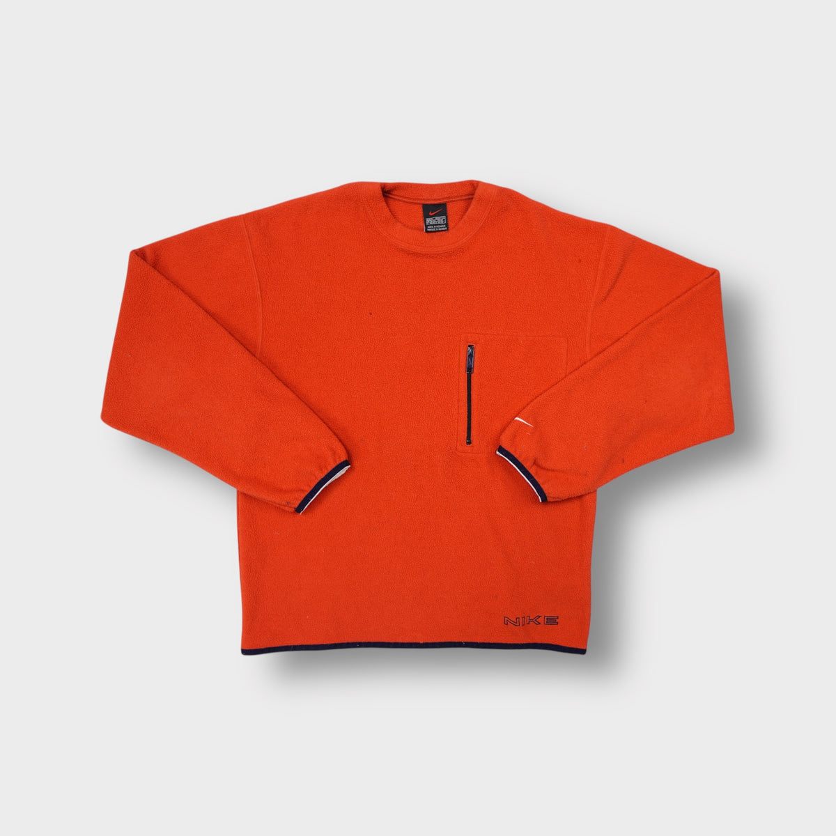 Orange Nike fleece sweater featuring a vertical zipped chest pocket and crewneck cut