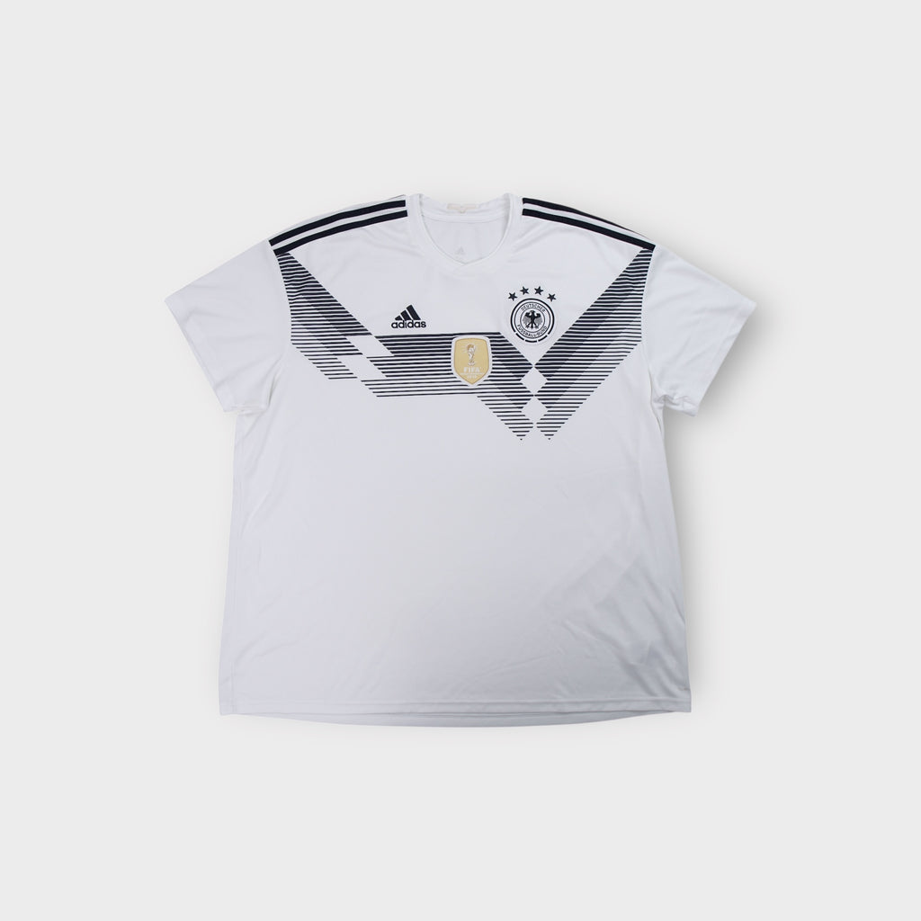 White Adidas DFB 2018 jersey with black geometric chest graphic and gold FIFA badge.