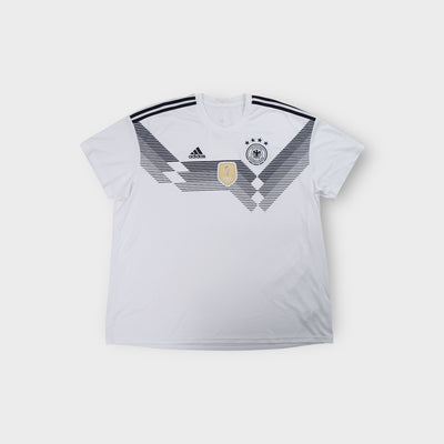 White Adidas DFB 2018 jersey with black geometric chest graphic and gold FIFA badge.