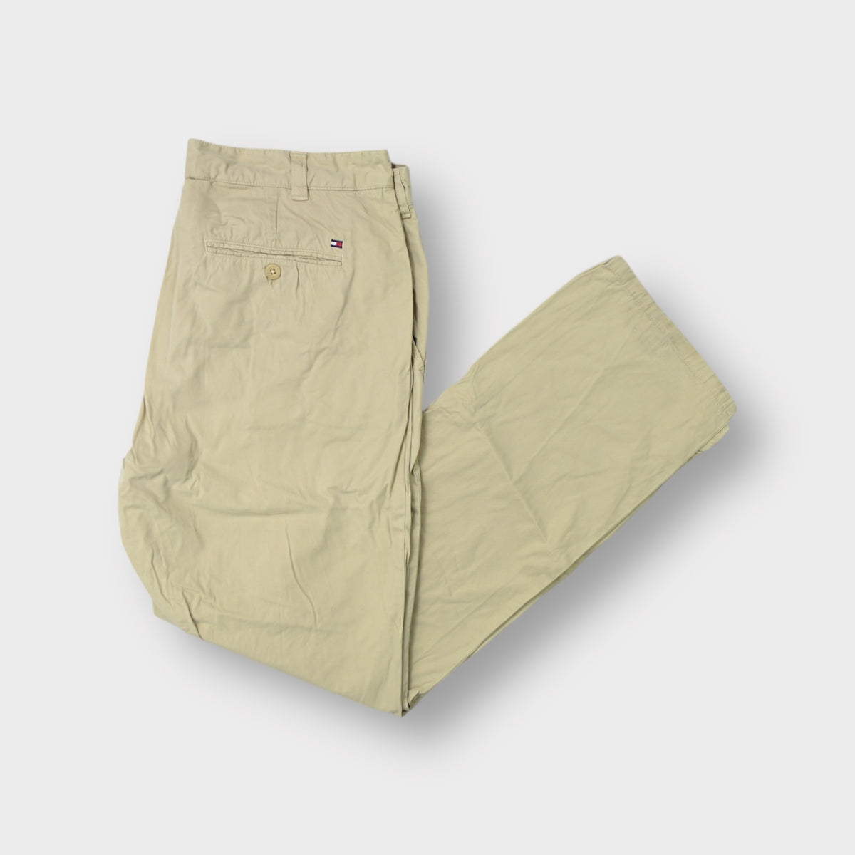 Tommy Hilfiger beige trousers featuring an embroidered flag patch on the back pocket