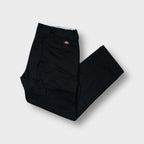 Black Dickies work trousers with a red woven logo patch above the back welt pocket