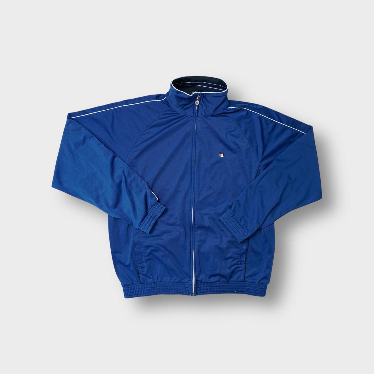 Champion blue track jacket with full zip and small embroidered logo on the chest