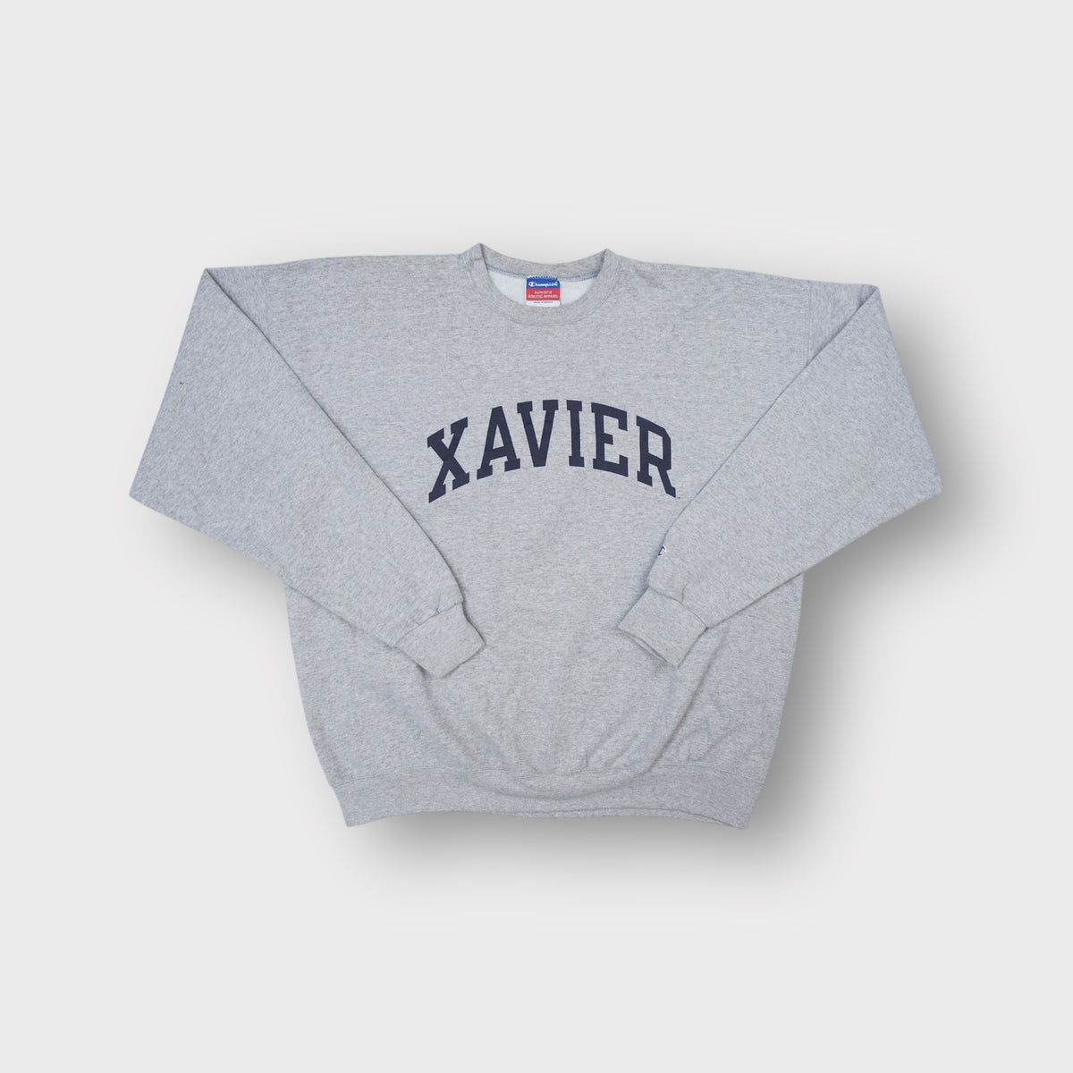 Grey Champion sweater with dark arched Xavier lettering printed on the front