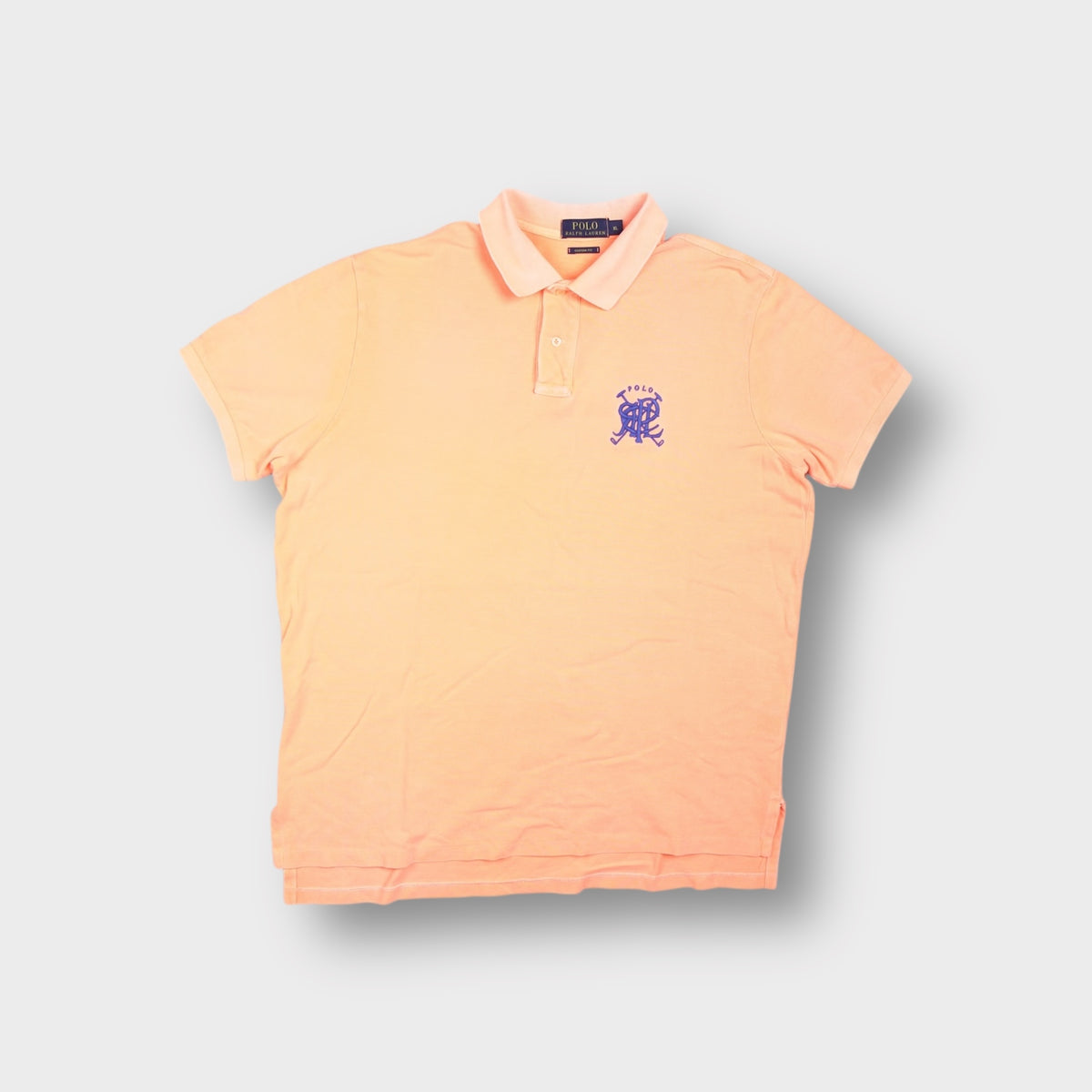 Ralph Lauren polo shirt in orange with a purple embroidered monogram crest on the chest