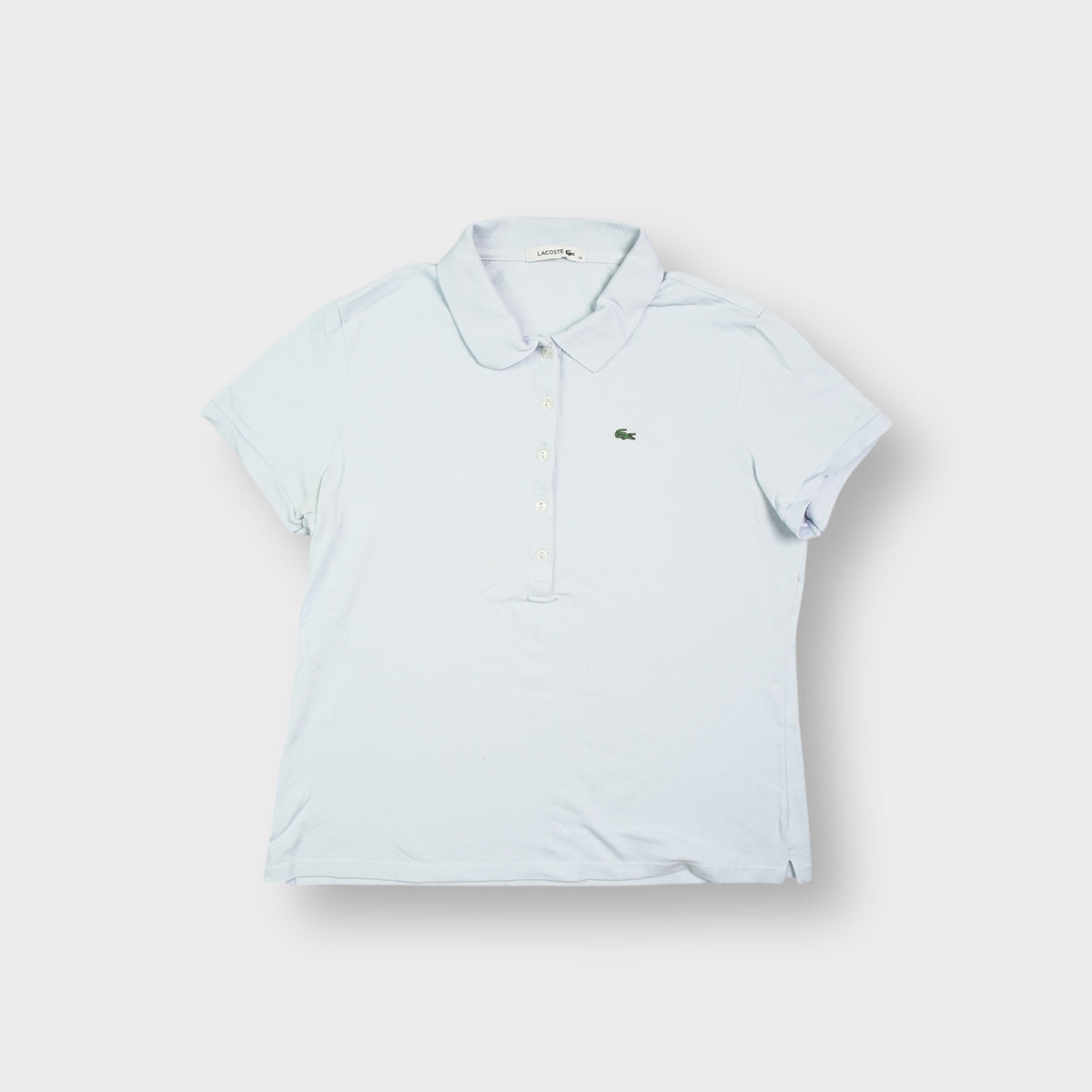 Lacoste polo shirt in light blue featuring an embroidered green crocodile on the chest.