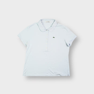 Lacoste polo shirt in light blue featuring an embroidered green crocodile on the chest.