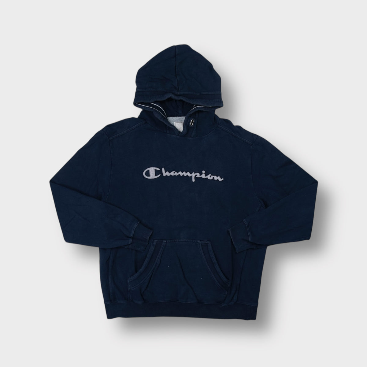 Champion hoodie in navy blue with grey cursive script logo applique on chest
