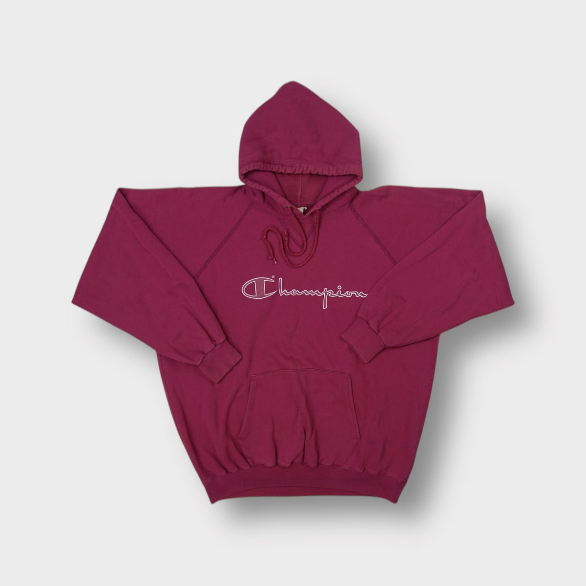 Red Champion hoodie featuring a white printed script logo on the chest