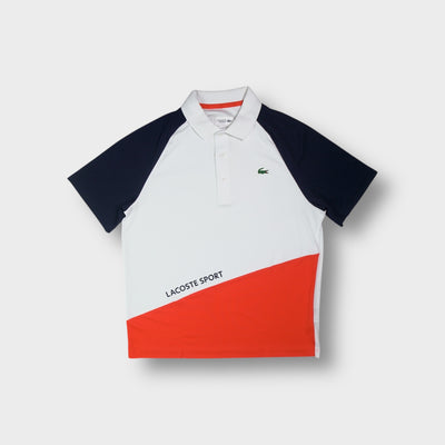 Lacoste Sport polo shirt in white with navy raglan sleeves and an orange diagonal lower panel