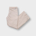 Beige Nike trackpants featuring an embroidered mini Swoosh on the upper front