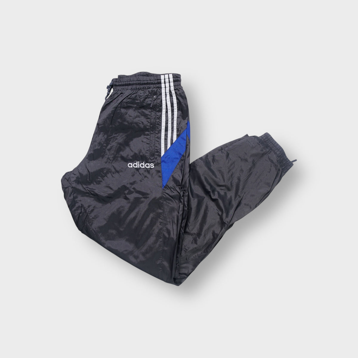 Adidas track pants in grey featuring white side stripes, blue panels and embroidered logo