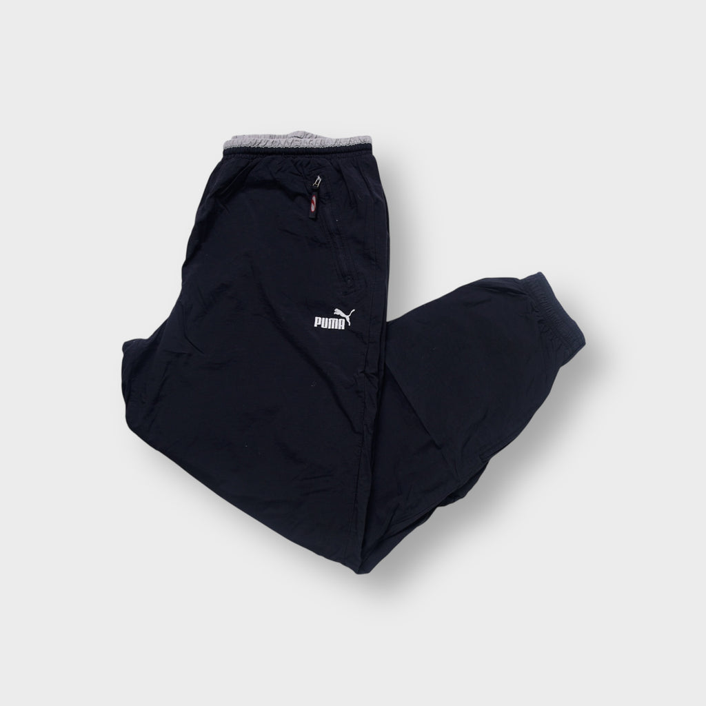 Puma trackpants in black with an embroidered white logo and zipped pockets