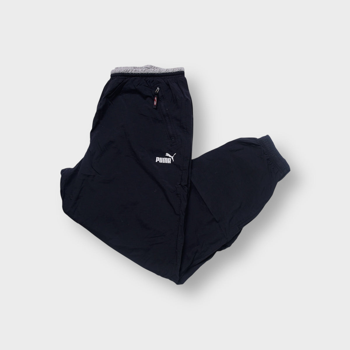 Puma trackpants in black with an embroidered white logo and zipped pockets