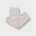 Nike beige trackpants showing an embroidered white swoosh logo near the side pocket