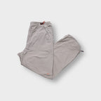 Nike trackpants in beige featuring red drawstring waist toggles and an orange swoosh logo.