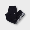 Black Adidas trackpants featuring white three-stripe trim and small embroidered logo.