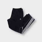 Black Adidas trackpants featuring white three-stripe trim and small embroidered logo.