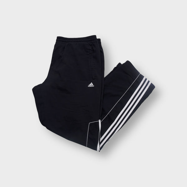 Black Adidas trackpants featuring white three-stripe trim and small embroidered logo.