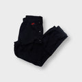 Black Nike trackpants featuring side snap buttons and a red embroidered logo