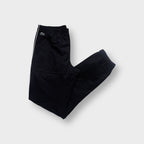Lacoste black trackpants featuring white side piping and a green crocodile patch near the waist