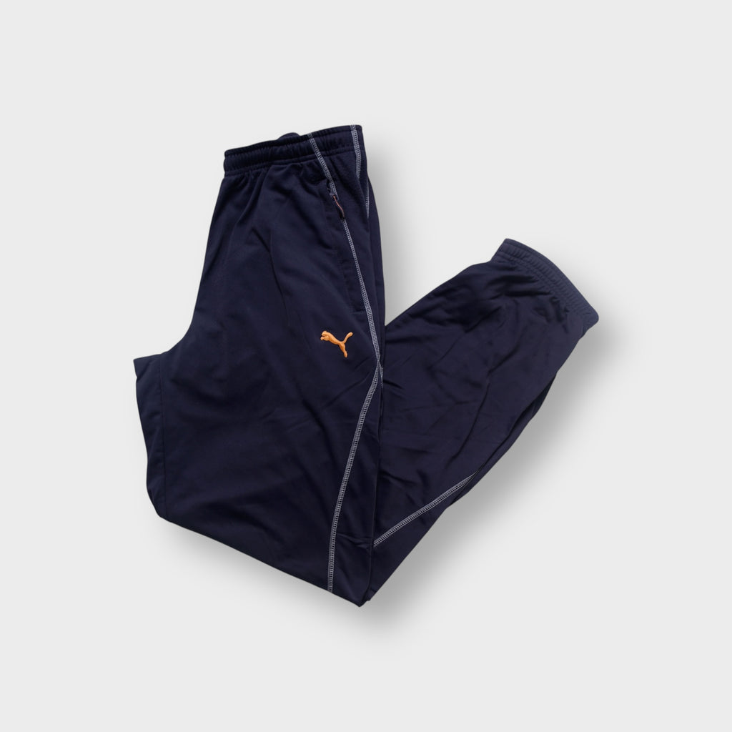 Puma trackpants in blue featuring contrast stitching and an embroidered orange logo