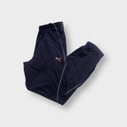Puma trackpants in blue featuring contrast stitching and an embroidered orange logo