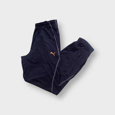 Puma trackpants in blue featuring contrast stitching and an embroidered orange logo