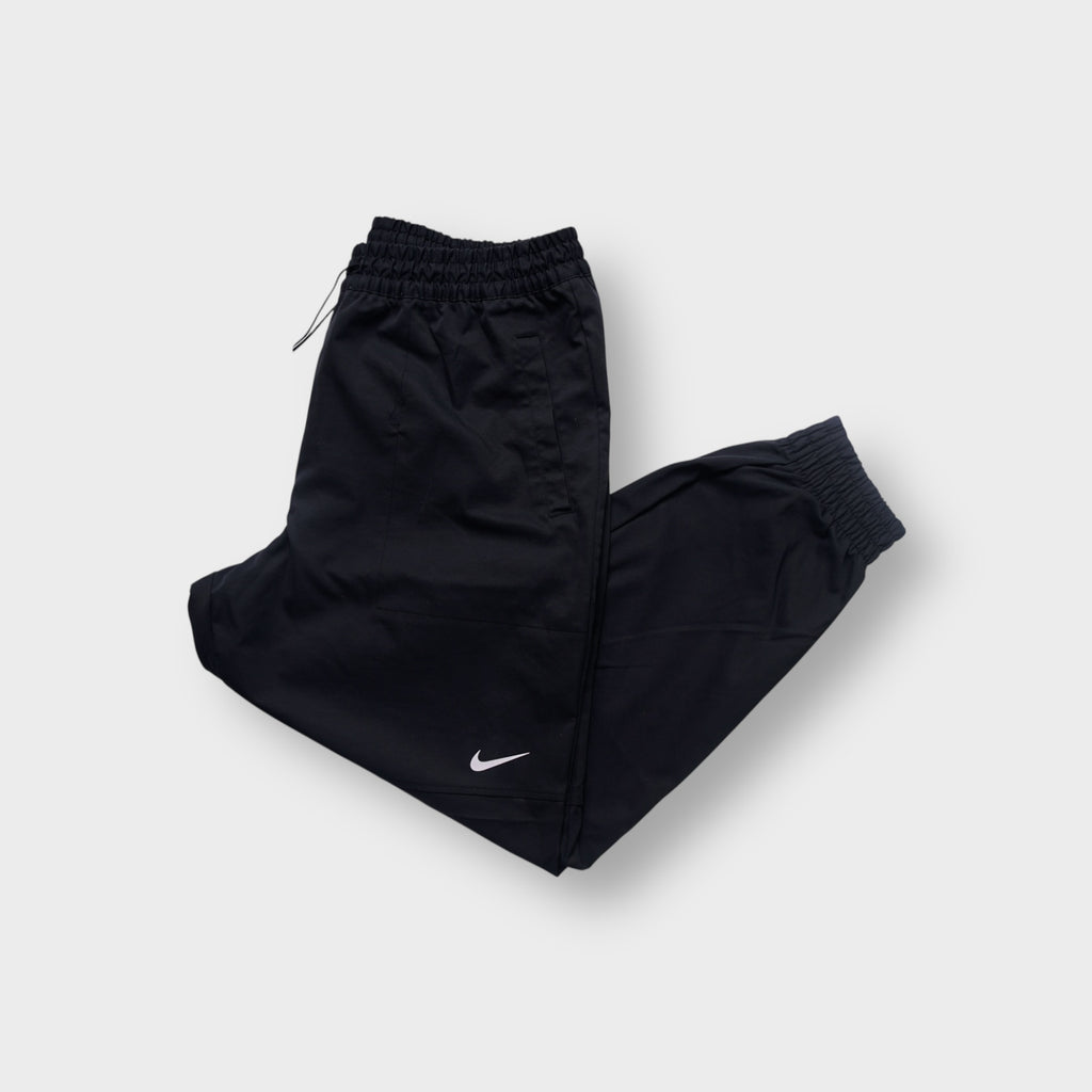 Nike black trackpants with a white embroidered swoosh logo on the leg