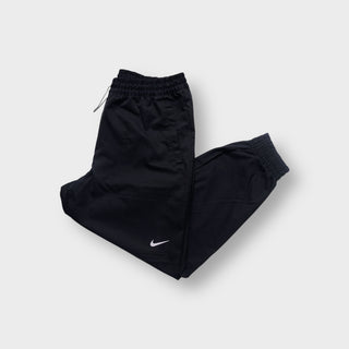 Nike black trackpants with a white embroidered swoosh logo on the leg