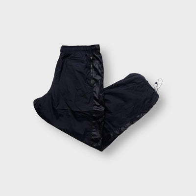 Nike trackpants in black featuring a tonal embroidered swoosh and ankle drawstrings.
