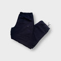 Nike trackpants in dark blue featuring a small white embroidered swoosh on the upper thigh