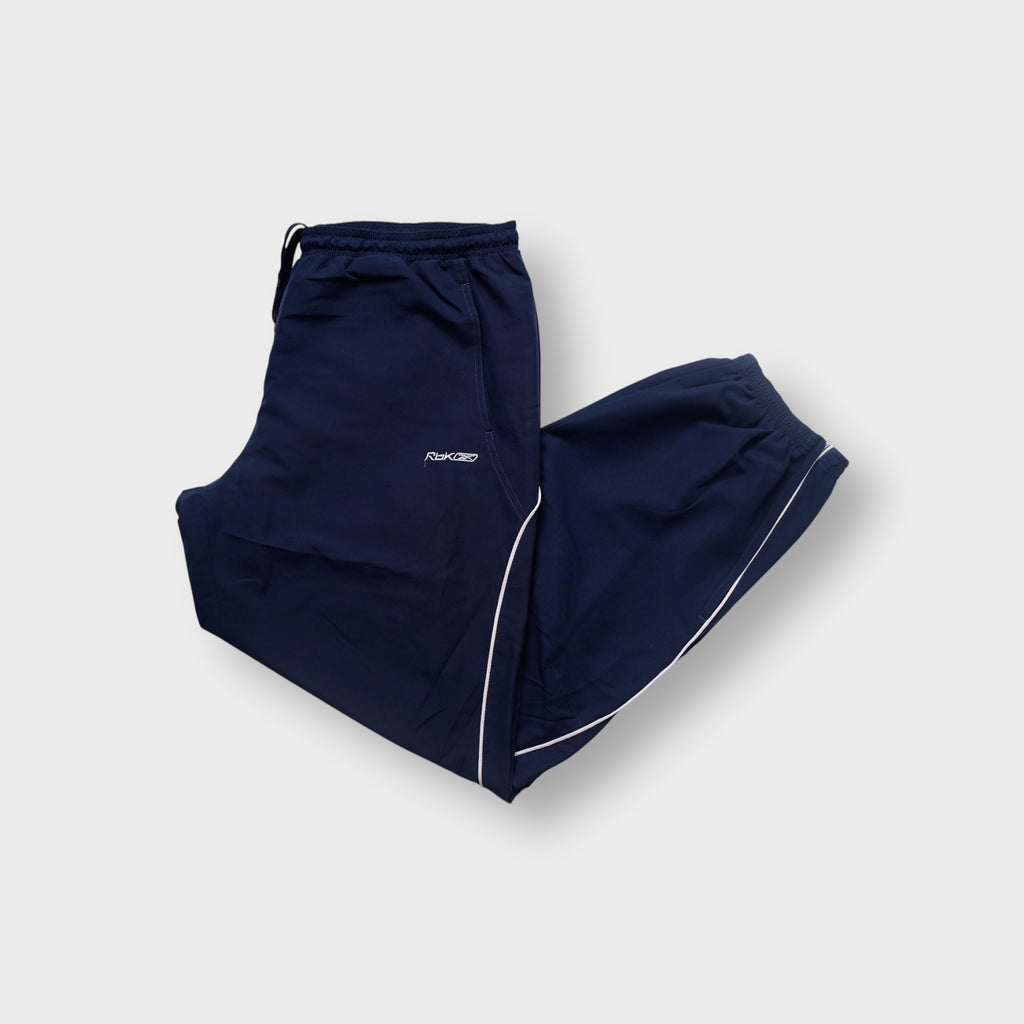 Reebok trackpants in dark blue with white piping trim and embroidered Rbk logo