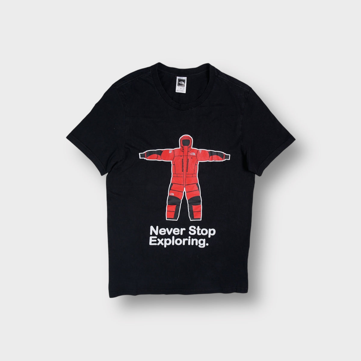 The North Face T-Shirt in black with a red expedition suit graphic on the front
