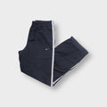 Nike trackpants in grey featuring white side stripes and an embroidered swoosh logo on the thigh.