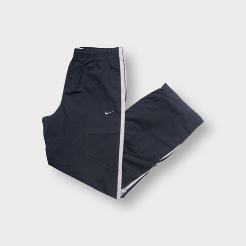 Nike trackpants in grey featuring white side stripes and an embroidered swoosh logo on the thigh.