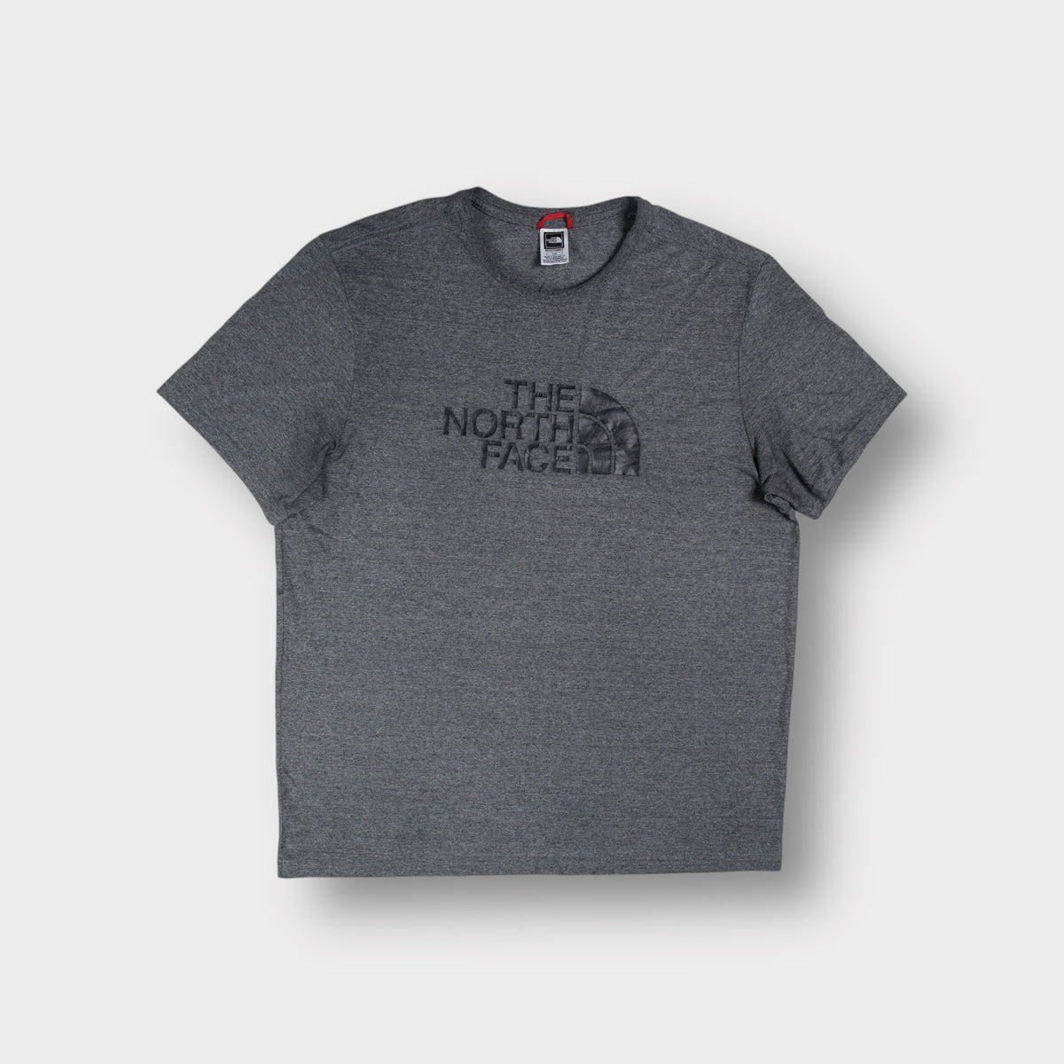 The North Face T-Shirt in heather grey with a dark raised logo print across the chest